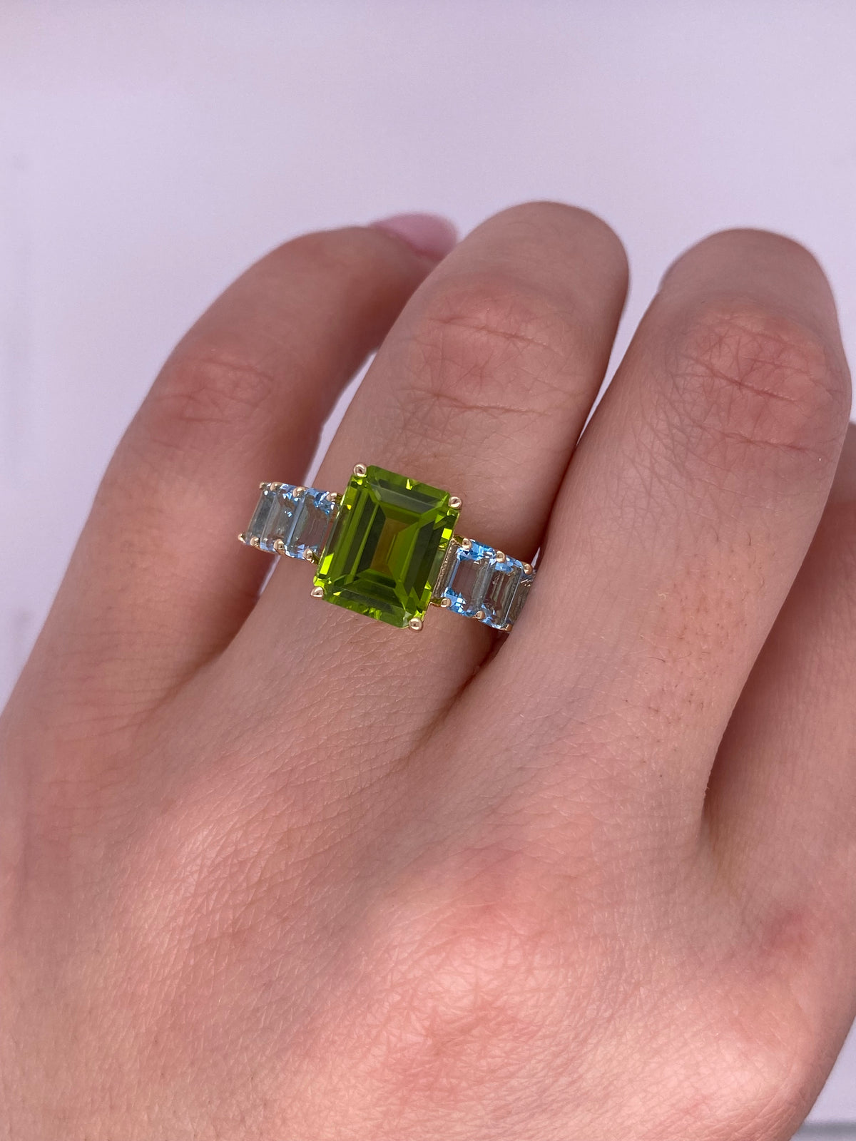 A0089 - Anillo peridoto central con topacio azul